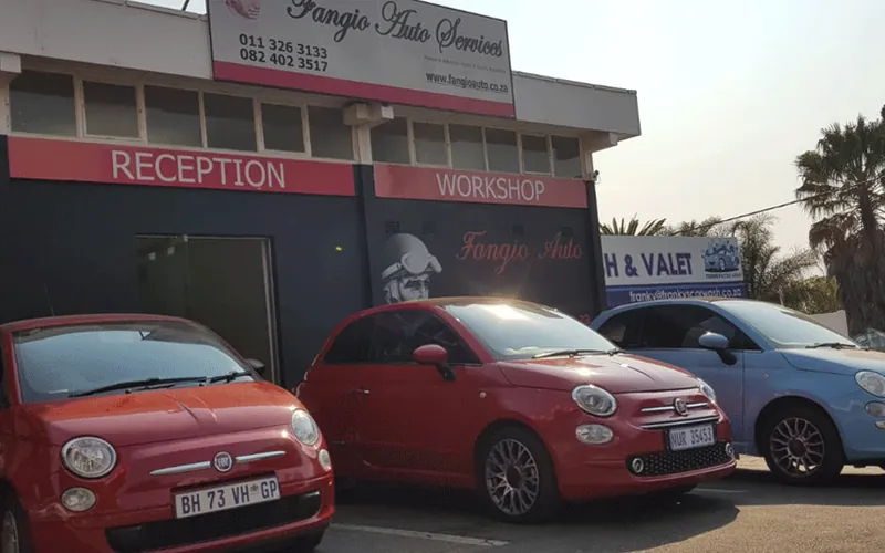 Fangio Auto Randburg today with its red reception and workshop signage and two Fiat 500s outside