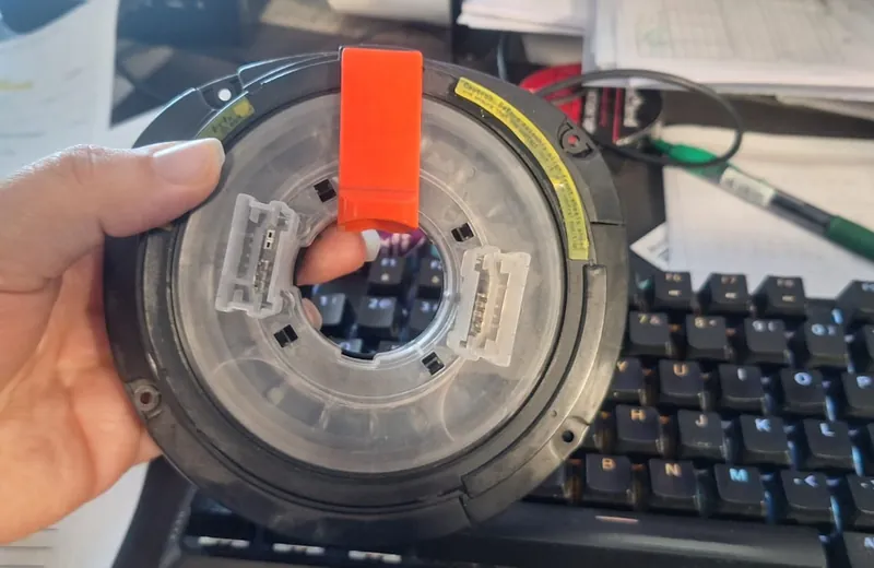 Steering airbag clock spring rotary connector held during replacement at Fangio Auto Hermanus