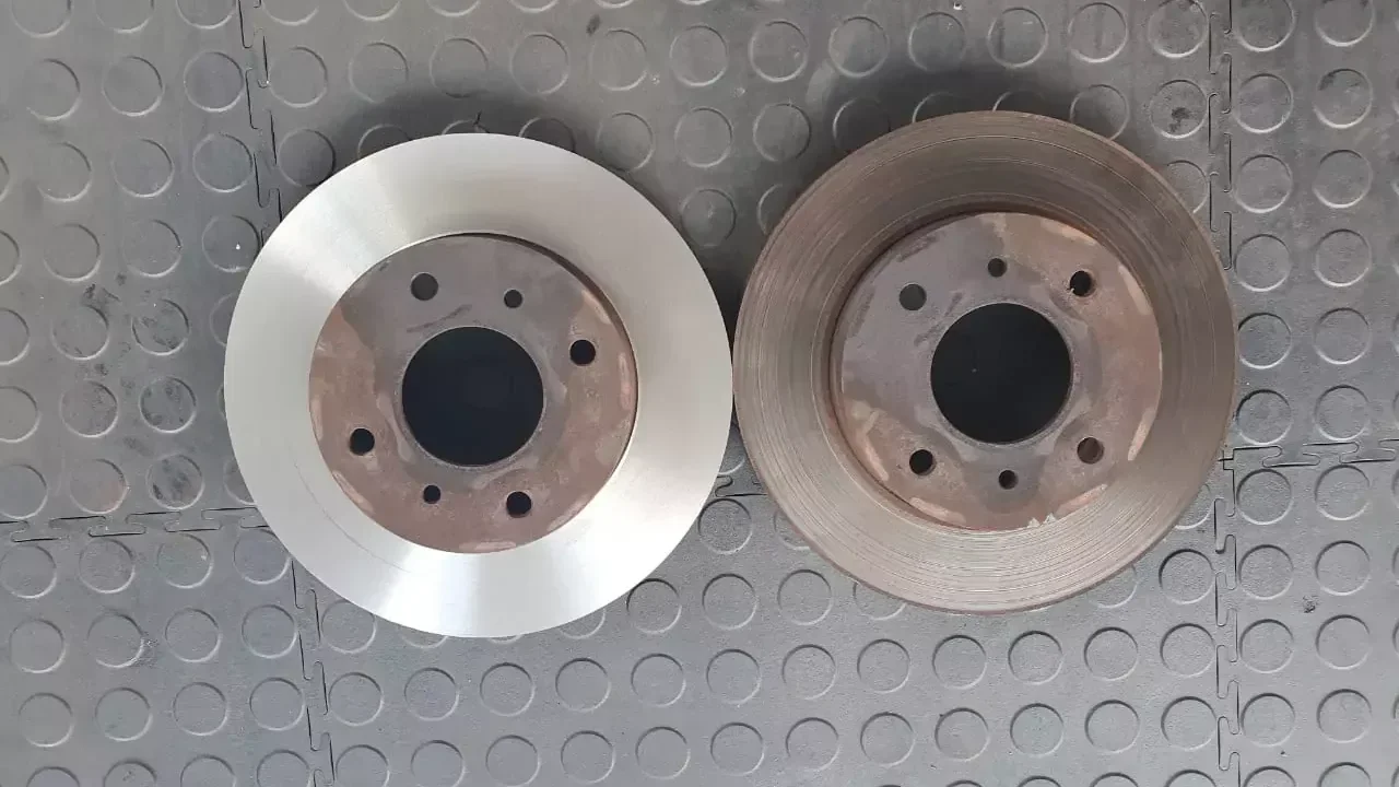 Freshly skimmed brake disc beside a worn brake disc in the Fangio workshop