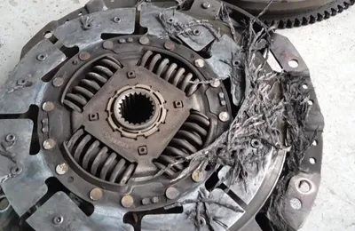 Damaged clutch disc and flywheel removed for replacement