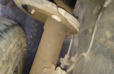Front shock absorber and coil spring inside a wheel arch during an inspection
