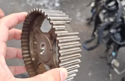 Worn timing sprocket and chain removed from an engine