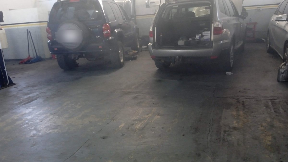 Cars in a workshop bay waiting for repairs