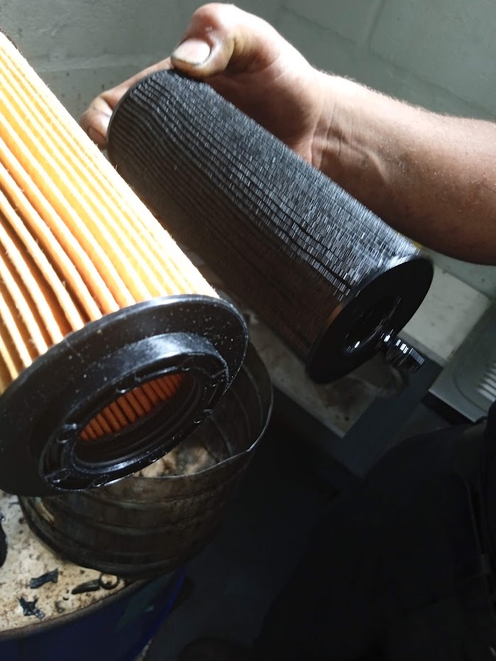 Used oil filter cartridge next to a new one during a BMW service at Fangio Hermanus