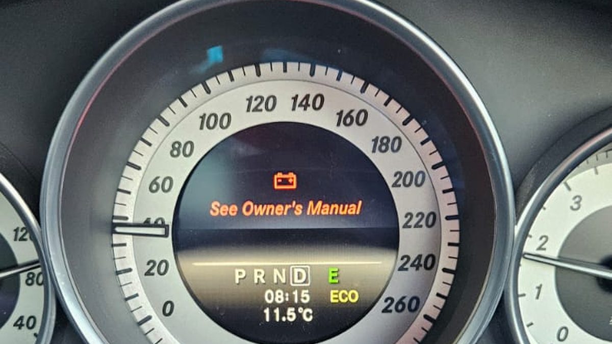 Battery warning symbol and See Owner's Manual message on a Mercedes instrument cluster