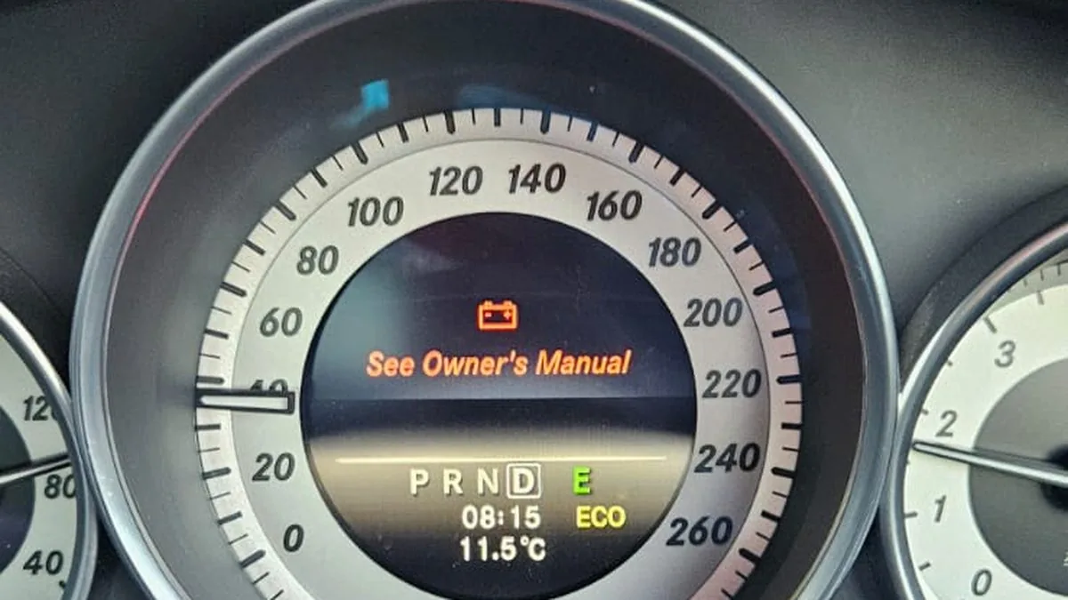 Battery warning symbol and See Owner's Manual message on a Mercedes instrument cluster