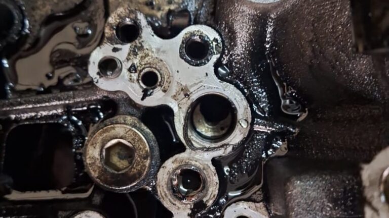 Engine oil leaking down the side of an engine block, the wet gasket face where the leak starts
