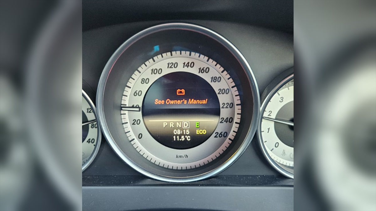 Mercedes C180 instrument cluster showing a red battery warning and See Owner's Manual message