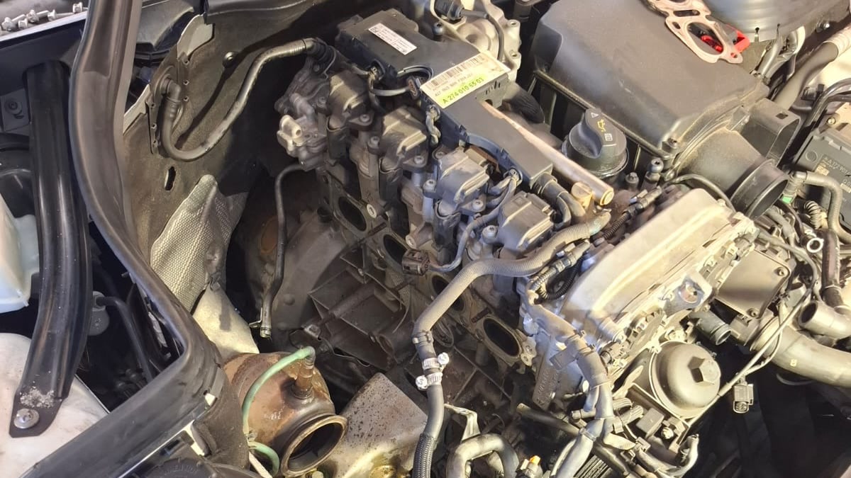 Mercedes engine bay stripped with the front end removed during a workshop repair