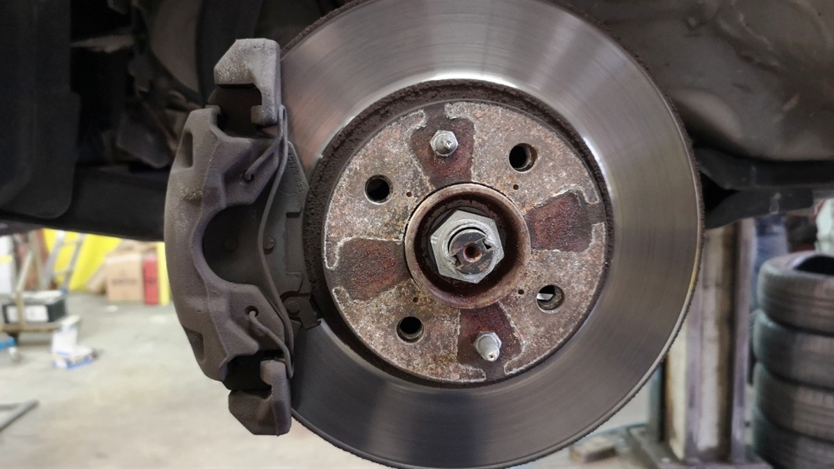 Brake disc and hub runout measured with a dial gauge in a workshop