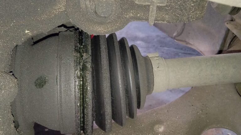 CV joint boot on a car split and leaking grease, a common sign a CV joint needs replacing