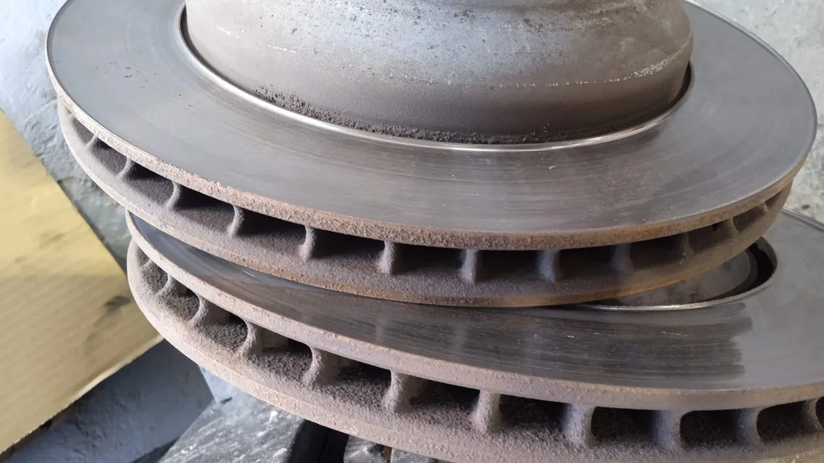 Two removed vented brake discs stacked on a workshop bench