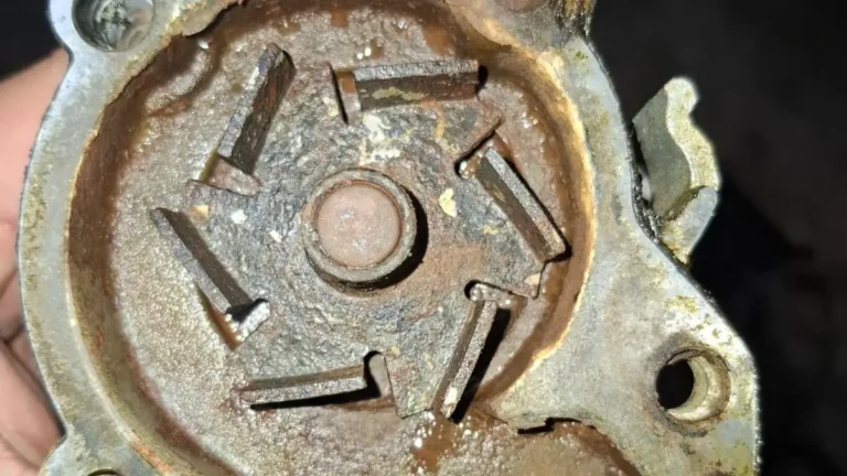 Water pump opened up showing a corroded impeller and rust sludge