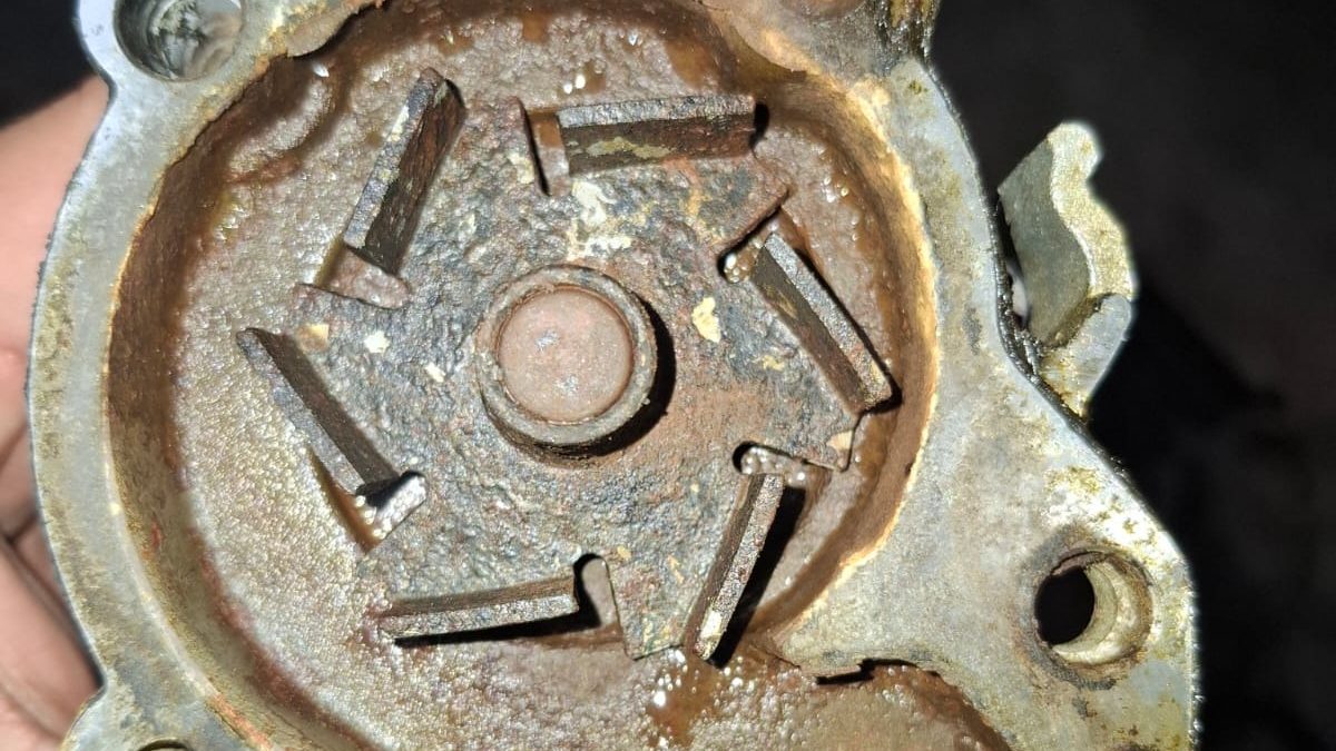 Water pump opened up showing a corroded impeller and rust sludge