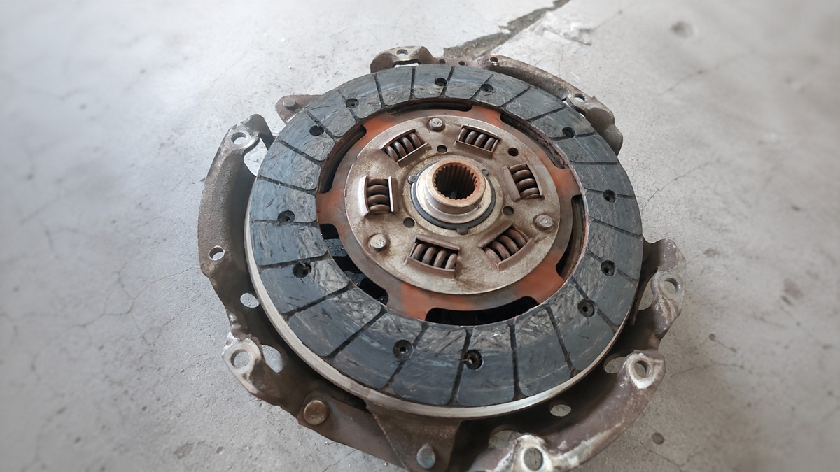 Worn clutch plate resting on its pressure plate